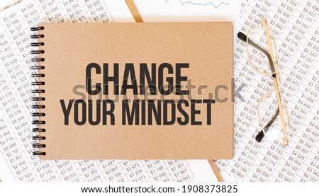 Craft colour notepad with text Change Your Mindset. Notepad with eyeglasses and text documents. Business concept