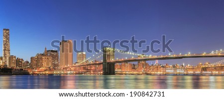New York City Manhattan midtown panorama at dusk with skyscrapers illuminated over river
