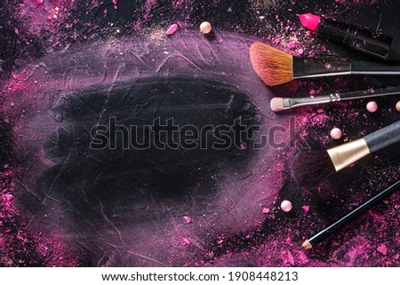 Make-up background with brushes and pearls. Makeup products and tools, shot from the top on a blackboard with copy space