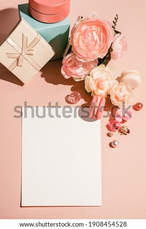 Abstract background with flowers, gifts boxes and a template for cards, invitations in pastel muted colors. Trendy pastel peach monochrome. Flat lay, copy space