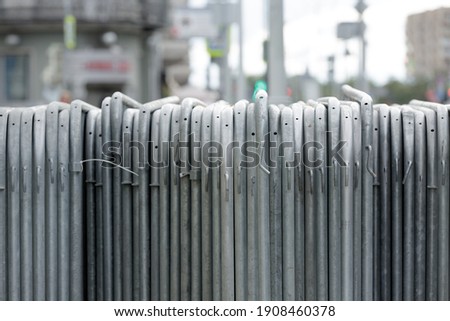 Temporary fence. Metal sections of temporary fencing, portable pedestrian barrier assembled and stand in a row Royalty-Free Stock Photo #1908460378