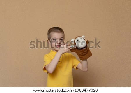 Vaccination concept. The boy gives a shot to a toy monkey. The child plays doctor.