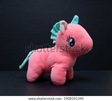 Pink unicorn isolated on black background