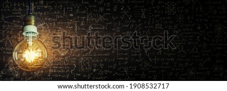 Glowing lamp as a symbol of scientific thought against the background of physical and mathematical formulas. Science and education background. Royalty-Free Stock Photo #1908532717