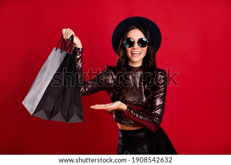 Photo of excited lady demonstrate black bags wear glossy top cap eyewear isolated red color background