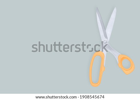 Barber scissors against red background background.