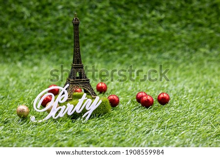 Eiffel towel with word PARTY is on green grass for French Party concept