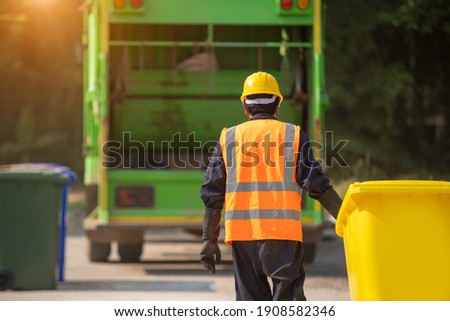 Worker collecting garbage of urban municipal are collecting for trash removal.  Royalty-Free Stock Photo #1908582346