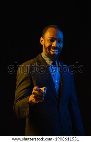 Portrait of young happy African-American man isolated on black background.