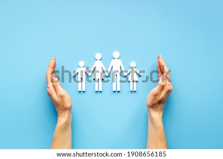 Hands holding family figure top view. Insurance concept