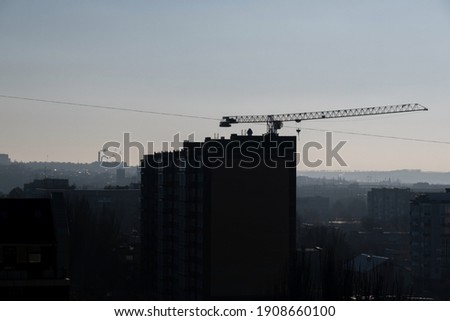 Silhouette Crane on construction site. Crane and building under construction
