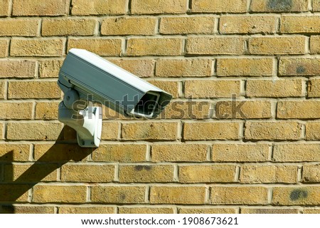 CCTV security camera system being used for surveillance purposes placed on a brick wall with copy space, stock photo image