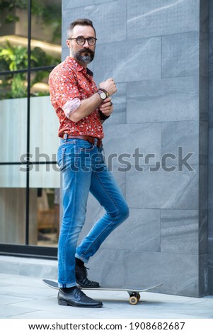 Stylish hipster bearded man skater riding a longboard go to working at the city. Alternative commute concept.