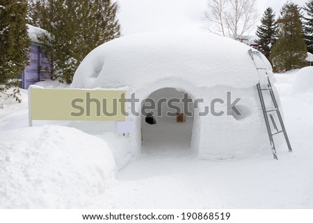snow shelter with blank yellow sign, for text or picture