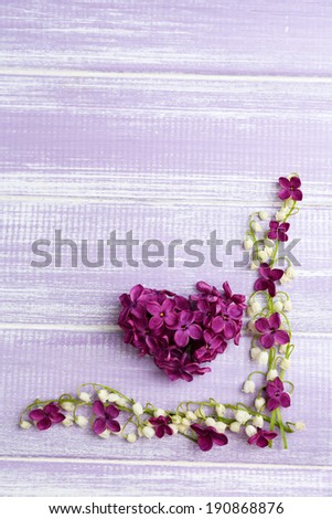 Beautiful lilac flowers and lilies of the valley, on wooden background