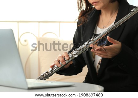 Flute classical instrument  player playing song. Instructor vlogger shooting video on bronze woodwind for orchestra as solo by online school learning through podcaster at home or in a studio.
