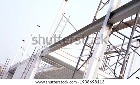 Construction site at day witb blue bright clear sky. Worker working at construction siteon steel and iron roof of underconstructed big and tall building as residence or company  on whitecbackground