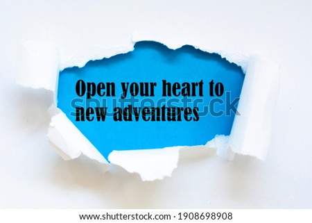 Open your heart to new adventures. Words written under torn paper. Motivation concept text.