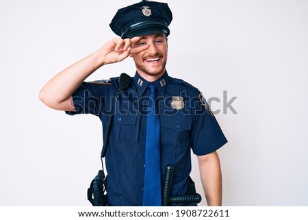 Young caucasian man wearing police uniform doing peace symbol with fingers over face, smiling cheerful showing victory 
