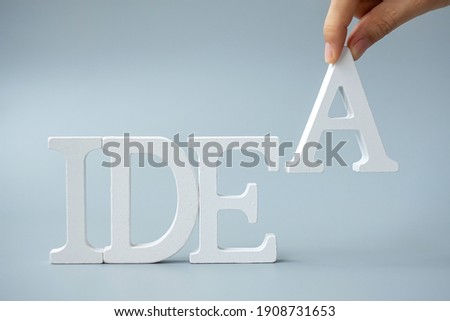 Businessman hand holding wooden IDEAS text on gray background. New Creative, Innovation, Imagination, inspiration, Solution, Strategy and GOAL concept