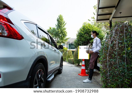 Curbside pick up.Store worker prepare and hold foods from customer order online delivery to customer in the outside.Social distance and contactless prevent covid-19.