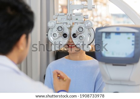 asian middle age woman eye exam with diagnostic ophthalmology in optical clinic. professional ophthalmic checking vision of patient. phoropter machine, Eye health check and ophthalmology concept. Royalty-Free Stock Photo #1908733978
