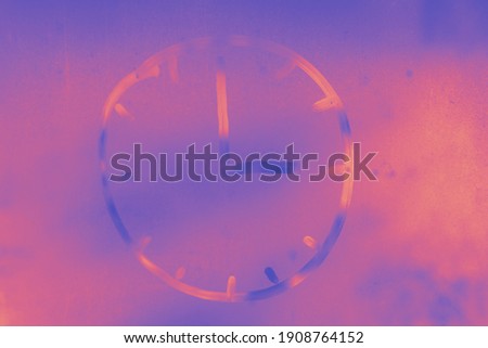 An abstract purple and pink picture with a clock painted on a misted window. Toned.