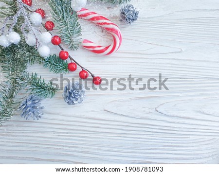 Christmas tree branch, candy on a wooden background