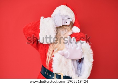 Old senior man with grey hair and long beard wearing traditional santa claus costume covering eyes with hands and doing stop gesture with sad and fear expression. embarrassed and negative concept. 