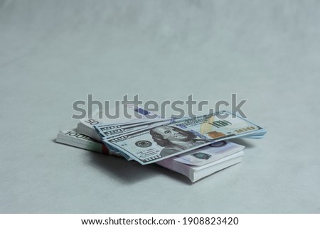 Bundles of dollar and euro bills on a light background