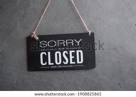 " Sorry we're closed " sign in black and white, vintage black retro sign in back wall
