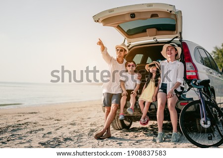 Holiday and travel family concept, Summer vacations.Happy family enjoying beach trip with their favorite car. Parents and children are traveling the way to the sea. Royalty-Free Stock Photo #1908837583