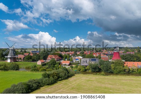Drone view, city shot with the twin mills at the old Greetsieler Sieltief. Greetsiel in Lower Saxony in Germany Royalty-Free Stock Photo #1908865408