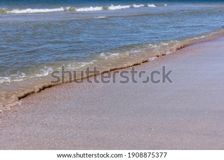 Wave foam on the sand beach. Focus on background.Vacation concept