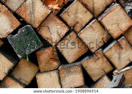 This is chopped wood laid in a woodpile. Preparation of fuel for the winter period for heating. These are wooden bars laid in a row. Close-up