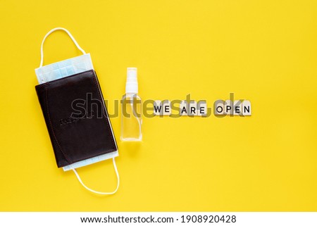 Accessories for travelers and text We are open on a yellow background. Coronavirus travel concept. Pandemic.