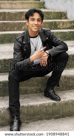 hispanic young man wears casual leather jacket, relaxed rock concept
