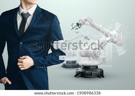 Image of a male businessman in a suit and robotic arms. Iot technology concept, smart factory. Digital manufacturing operation. Industry 4.0.