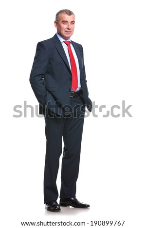 full length picture of a mid aged business man holding his hands in his pockets and looking into the camera. isolated on a white background