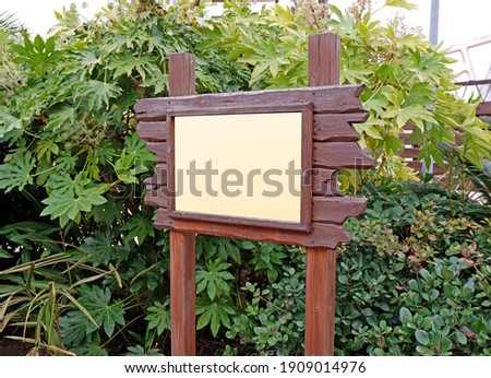 Wooden blank sign board in the green park