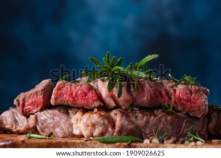 Close-up of delicious beef steak on a wooden table, still life. Rare steak