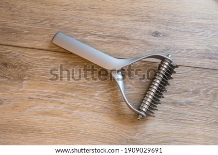 Dog grooming and bathing tools close up. two sided undercoat rake. Royalty-Free Stock Photo #1909029691