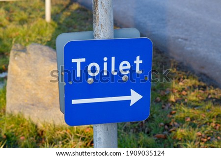 Blue toilet sign to public restrooms