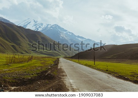 Empty mountain road way. Ecotourism, getaway, roadtrip concept. Calm land nature background. Photo with copy space. Scenic Image of Caucasian, cinematic aesthetic.