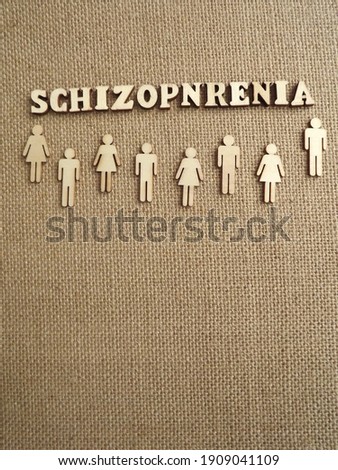 mental illness-schizophrenia in the form of wooden letters and figures of people on a jute background. High quality photo
