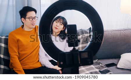 Asian couple, recording video with phone camera. Influencers streaming on social media. High quality photo