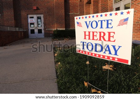 A Vote Here Today sign stands outside of a polling place.