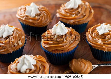 Tasty cupcakes with dulce de leche on a wooden table. Image with selective focus.