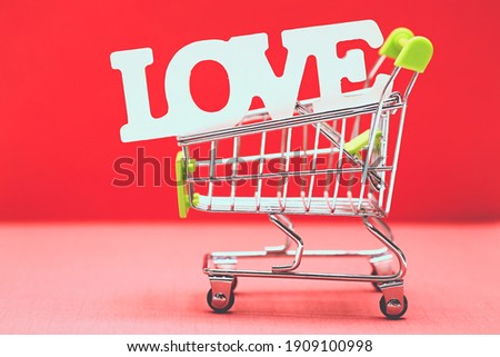 Valentine day concept from word love in shopping trolley on red paper background