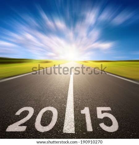 Driving on an blurred empty asphalt road forward to new 2015